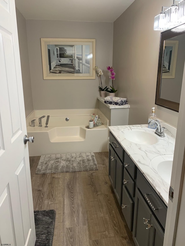 bathroom featuring hardwood / wood-style flooring, a bath, and double vanity