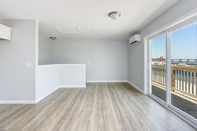 empty room with a wall unit AC and light hardwood / wood-style flooring