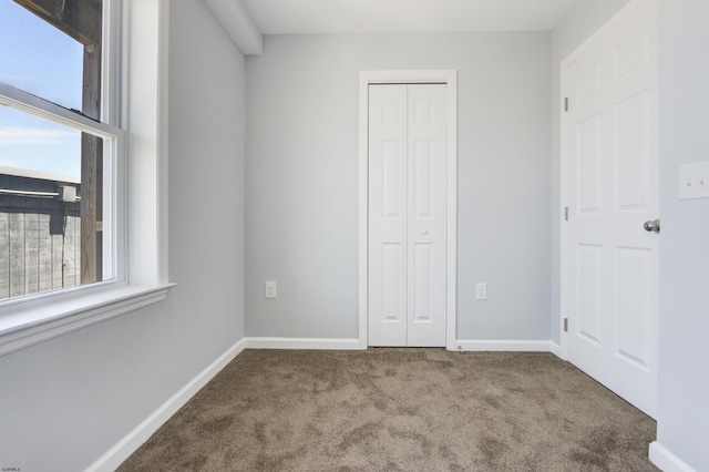 unfurnished bedroom featuring light carpet and multiple windows