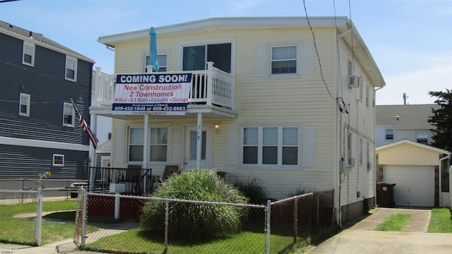 view of front of property featuring an outbuilding, a balcony, a garage, and a front yard