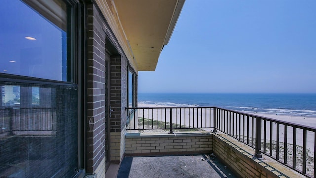 balcony with a water view and a beach view