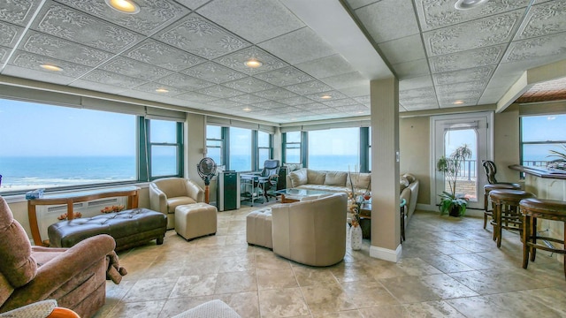 tiled living room with a healthy amount of sunlight and a water view