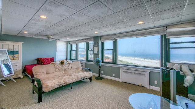 living room featuring carpet floors, radiator heating unit, a water view, and ceiling fan