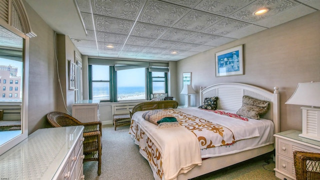 bedroom with carpet flooring, access to exterior, and a water view