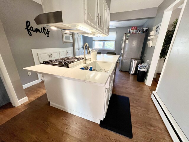 kitchen with white cabinets, hardwood / wood-style floors, and stainless steel dishwasher