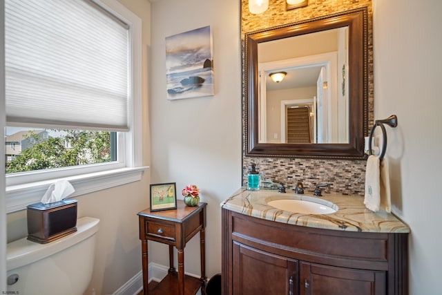 bathroom featuring tasteful backsplash, vanity, and toilet