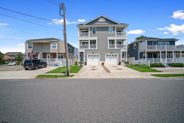 view of front facade featuring a balcony, a garage, and a front yard