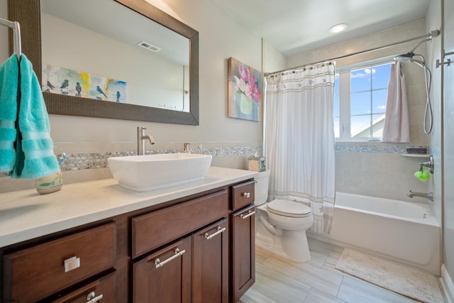 full bathroom with shower / tub combo with curtain, vanity, and toilet