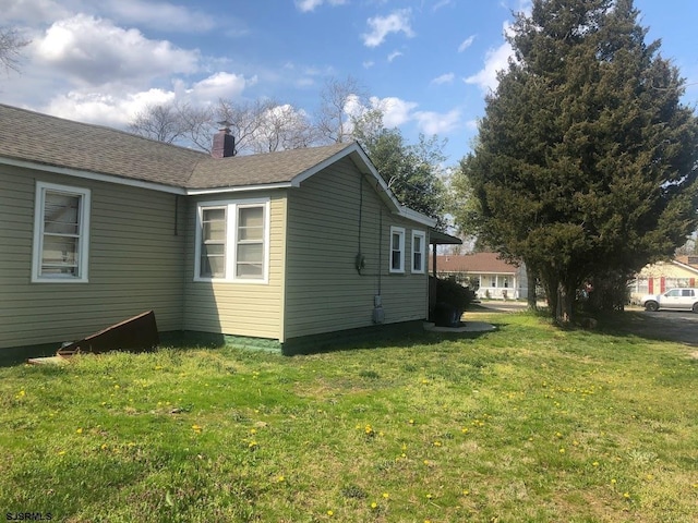 view of side of property with a yard