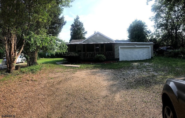 view of yard featuring a garage and a porch