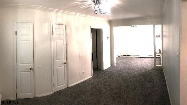 hall featuring a baseboard radiator, ornamental molding, and dark colored carpet