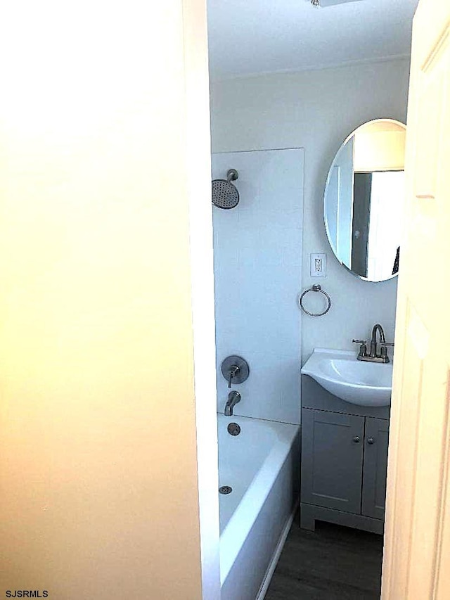 bathroom with tiled shower / bath combo, vanity, and hardwood / wood-style floors