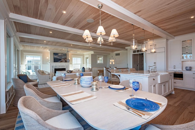 dining room featuring beam ceiling, a wealth of natural light, dark hardwood / wood-style floors, and sink