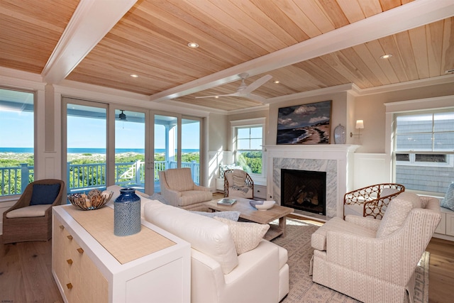 living room featuring hardwood / wood-style floors, a high end fireplace, and beamed ceiling