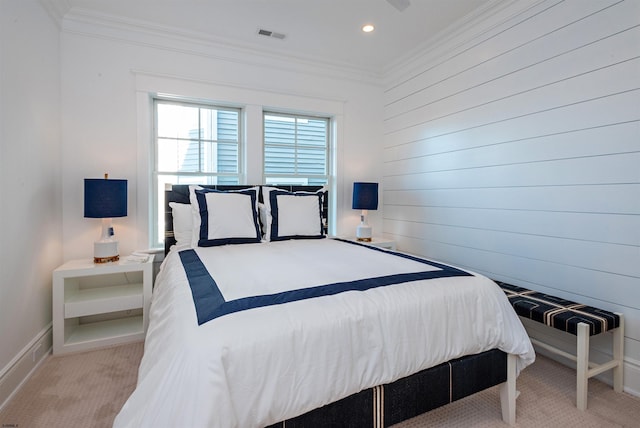 bedroom with light carpet, wood walls, and crown molding