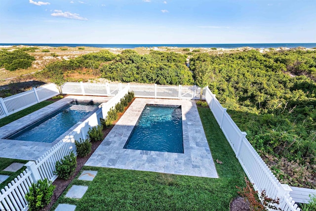 view of swimming pool with a water view and a lawn