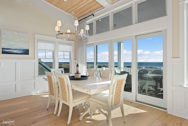 dining area with a water view, wood ceiling, a chandelier, and light hardwood / wood-style floors