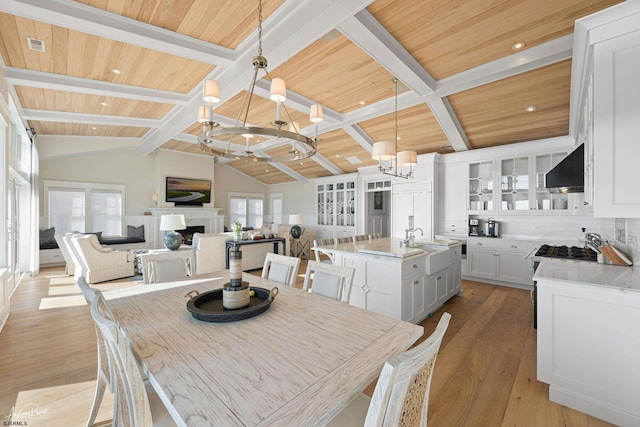 dining space with wooden ceiling, a wealth of natural light, lofted ceiling with beams, and an inviting chandelier