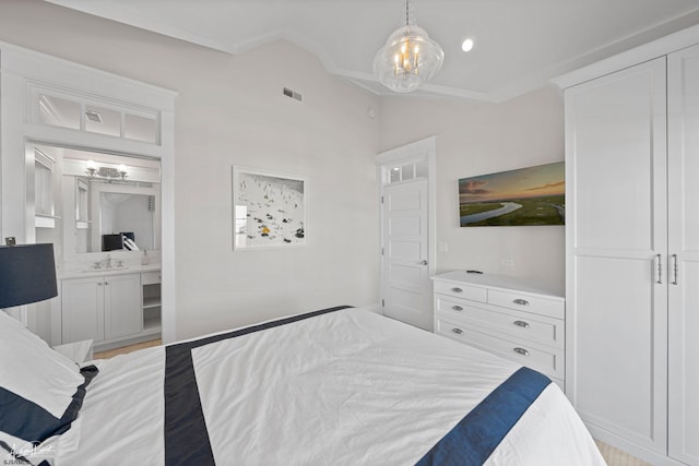 bedroom with connected bathroom, sink, and ornamental molding