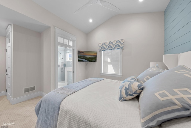 bedroom with ensuite bath, light colored carpet, ceiling fan, and vaulted ceiling