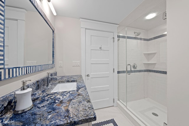 bathroom with an enclosed shower, vanity, and tile patterned flooring