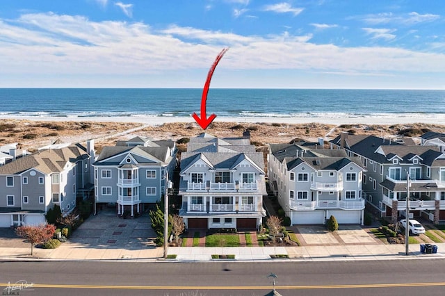 birds eye view of property featuring a water view and a beach view