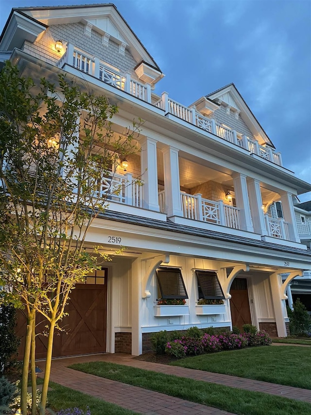 view of front of property featuring a balcony and a front lawn