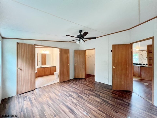 unfurnished bedroom featuring hardwood / wood-style flooring, connected bathroom, a closet, and ceiling fan