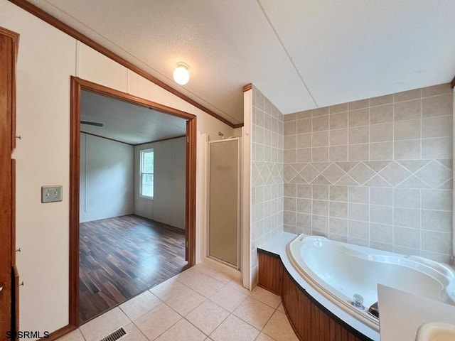 bathroom featuring tile patterned floors, tile walls, ornamental molding, vaulted ceiling, and plus walk in shower