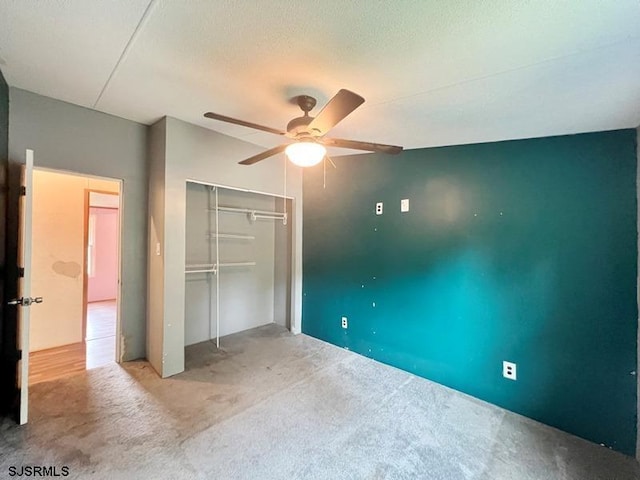 unfurnished bedroom featuring ceiling fan, carpet, a closet, and a textured ceiling