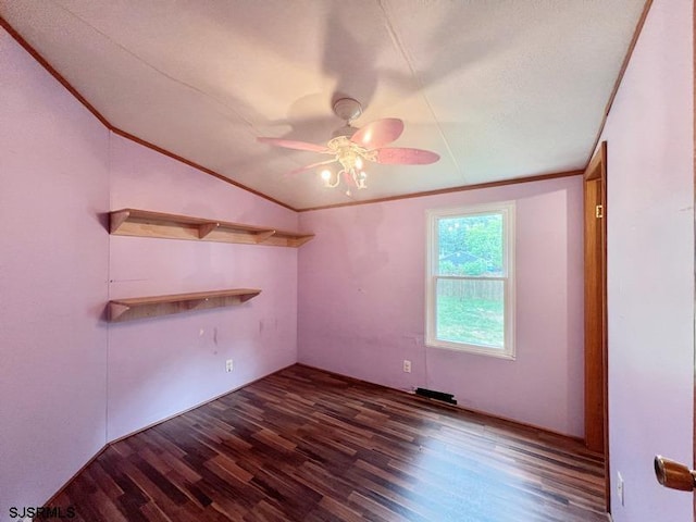 spare room featuring ceiling fan, vaulted ceiling, dark wood-type flooring, and ornamental molding