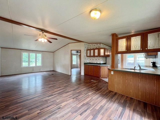 kitchen featuring kitchen peninsula, ceiling fan, dark hardwood / wood-style floors, lofted ceiling, and sink