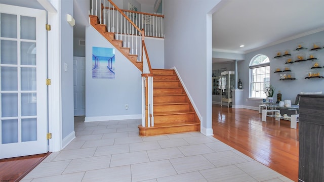 staircase with ornamental molding and wood-type flooring