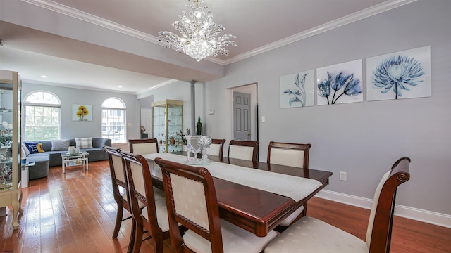 dining space with hardwood / wood-style flooring, ornamental molding, and a chandelier