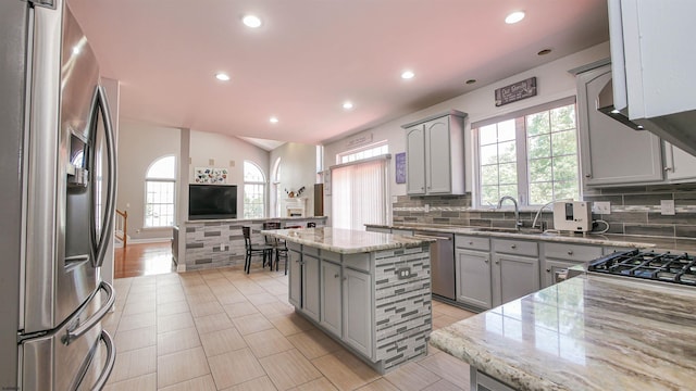 kitchen featuring a kitchen island, appliances with stainless steel finishes, sink, and gray cabinetry