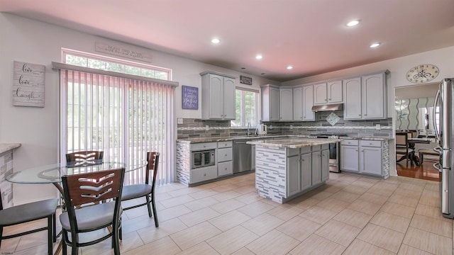 kitchen featuring tasteful backsplash, appliances with stainless steel finishes, and gray cabinetry