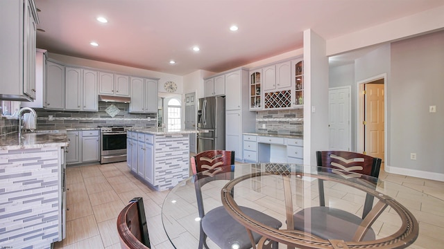 kitchen with a kitchen island, appliances with stainless steel finishes, sink, gray cabinetry, and decorative backsplash