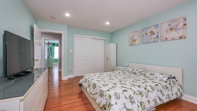 bedroom with hardwood / wood-style floors and a closet