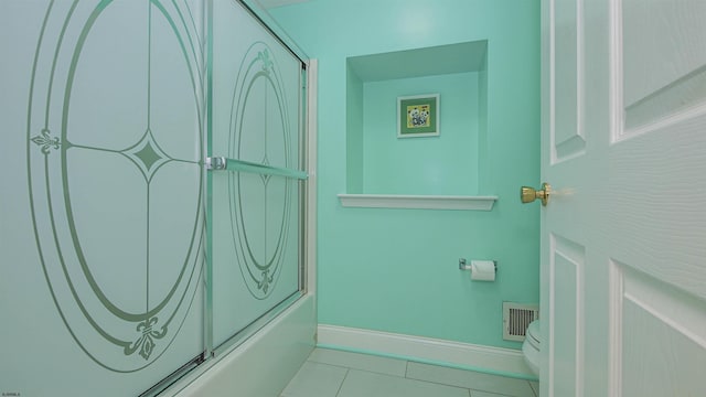 bathroom with tile patterned flooring and shower / bath combination with glass door