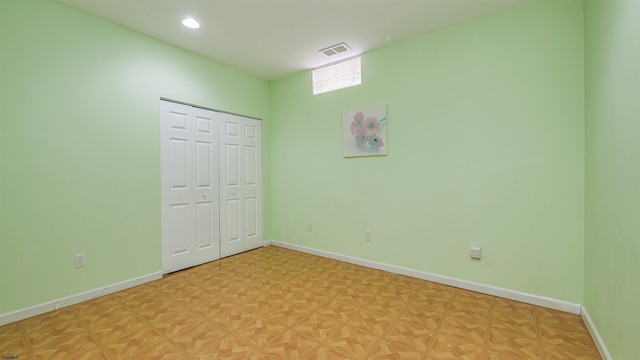 unfurnished bedroom featuring light parquet floors and a closet