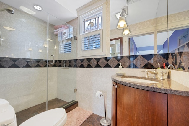 bathroom featuring tile walls, backsplash, toilet, a stall shower, and vanity