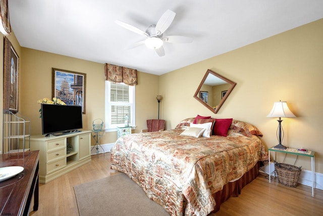 bedroom with light wood-type flooring, baseboards, and a ceiling fan