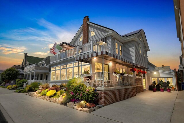 exterior space featuring a balcony, a garage, and a sunroom