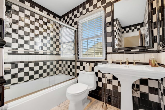 bathroom with enclosed tub / shower combo, toilet, tile walls, and decorative backsplash