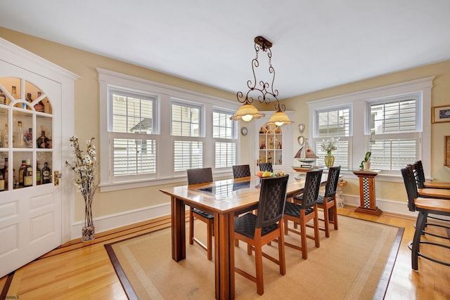 dining area with light wood-type flooring and baseboards