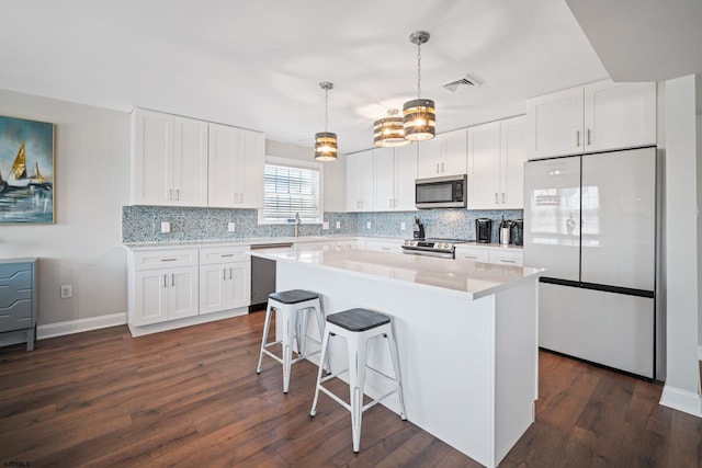 kitchen with dark hardwood / wood-style floors, stainless steel appliances, and white cabinets