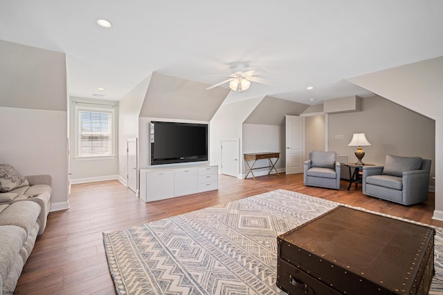 living room featuring hardwood / wood-style flooring, ceiling fan, and vaulted ceiling