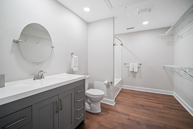 full bathroom with vanity, toilet, wood-type flooring, and  shower combination