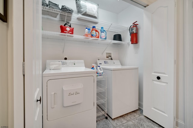 laundry room with light tile patterned flooring and washing machine and dryer