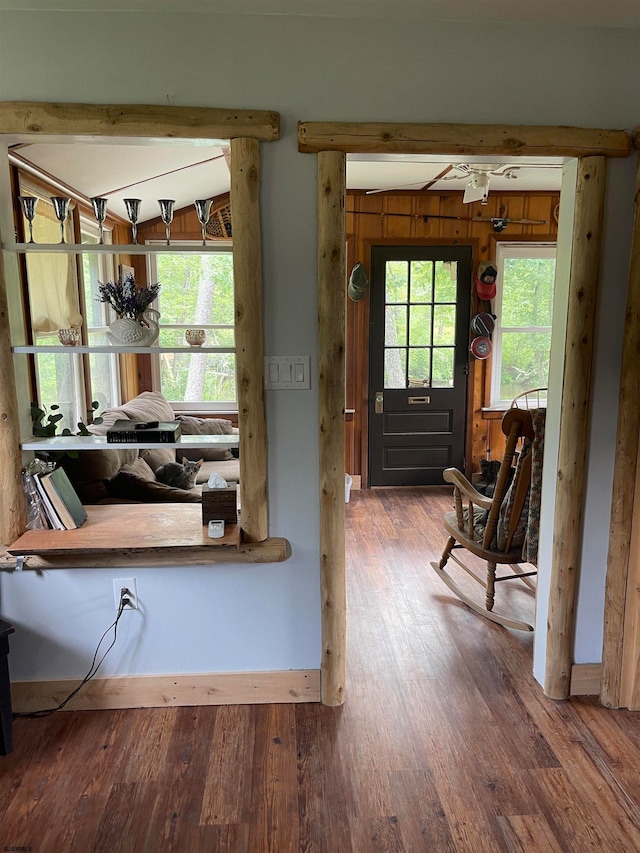 entrance foyer with wood-type flooring, wood walls, and a wealth of natural light